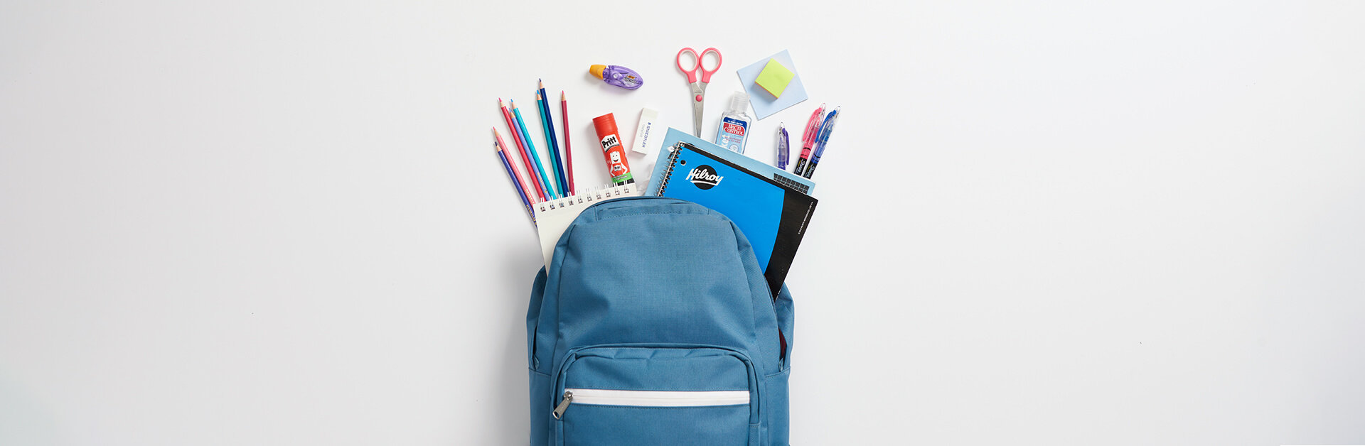 Blue back pack with and assortment of school supplies.